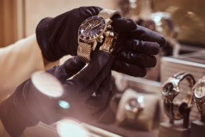 Close-up of the seller's hands in gloves shows the exclusive men's watch from the new collection